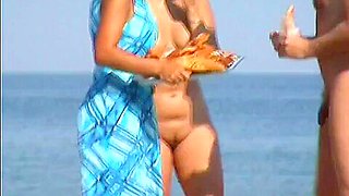 Nudist beach voyeur video of a mature brunette with big tits